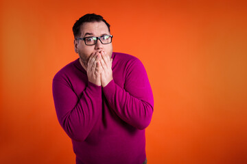 The funny man was scared and surprised. Orange background.