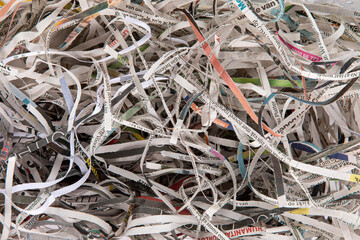 Shredded newspaper pieces are creating an abstract textured background. Full frame top view.