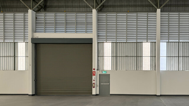 Elevation of interior factory showing steel roller shutter door, steel fire exit door, metal sheet siding, and louvers.