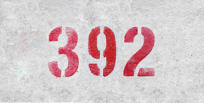Red Number 392 on the white wall. Spray paint.
