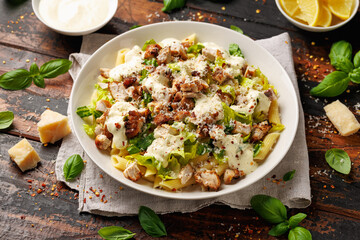 Chicken Caesar Pasta Salad with sauce in white plate. Healthy food.