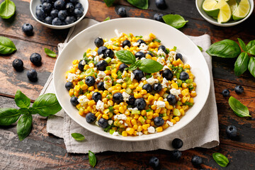 Blueberry Corn Feta Salad in white plate on wooden table. Healthy food