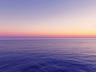 Fototapeta premium The ocean stretches out to the horizon with a calming purple hue, as the sunset paints the sky with soft pink and purple tones