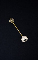 A copper key on a black background. The key to the front door.