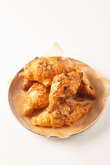 Freshly baked croissants with almonds on a white plate