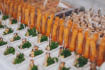 churro bar at wedding reception, churros at event, close up. Various snacks on table, banquet food. buffet table served with exotic food. delicious festive buffet with canapes and different meals 