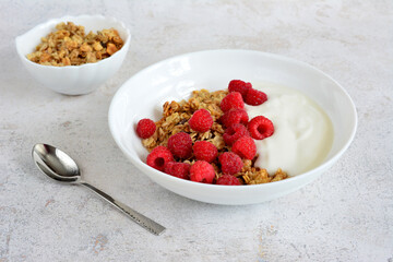 a bowl of cereal with raspberries and yogurt   