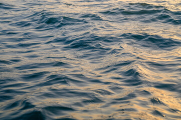 Sunset by the sea, the sky is reflected in the smooth sea