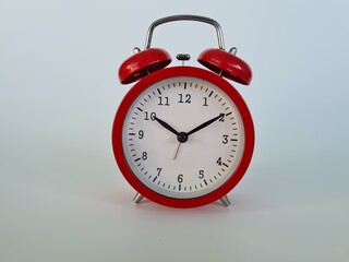 Red Alarm Clock Set to Ten Minutes Past Ten