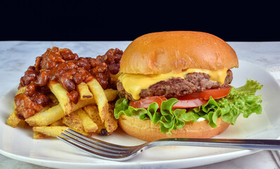 cheese burger with fries top with chili