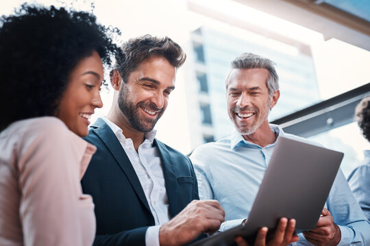 Business people, laptop and laughing for research in collaboration for funny website review or reading project feedback. Marketing team, employees or tech for b2b networking or planning ideas at work