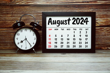 AUGUST 2024 monthly calendar for planning and management concept with alarm clock on wooden...