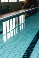 Fototapeta premium Clear water reflections in an indoor swimming pool lane