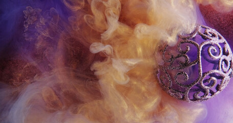 Color smoke. Paint water. Esoteric ball. Neon purple gold yellow ink splash swirl shimmering ornament bauble vapor texture abstract art background.