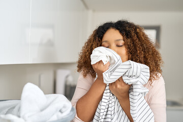 Woman, home and smelling clothes for laundry for household keeping, fresh scent and hygiene. Female...