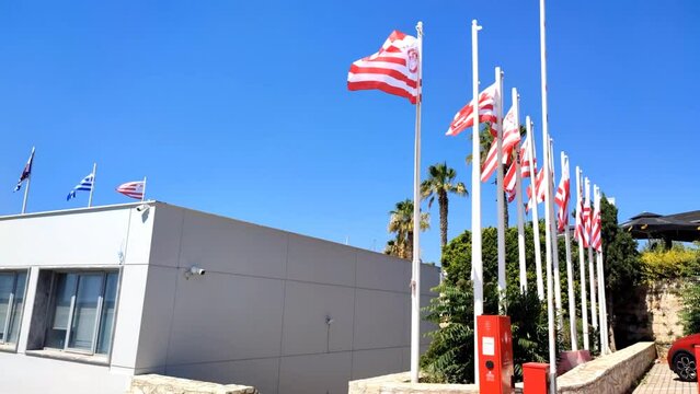 Video of the Olympiacos football club flags waving outside its office headquarters on Aleksandras Square in Piraeus, Greece.