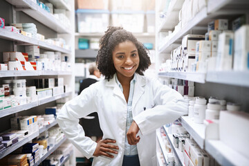 Healthcare, pharmacist and black woman in shop, portrait and inventory of shelf with medicine for shortage. Pharmacy, proud and person in coat, smile and happy with oath to save lives in store