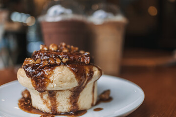 Caramel bun bakery dessert served on wooden table in the cafe.