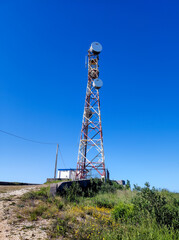 Communication tower with antennas prepared for mobile phones and internet under a clear blue sky