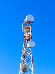 Communication tower with antennas prepared for mobile phones and internet under a clear blue sky