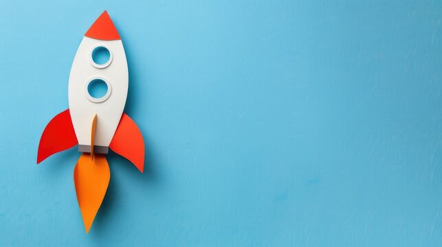 Rocket paper craft taking off with copy space on a blue background symbolizing back to school