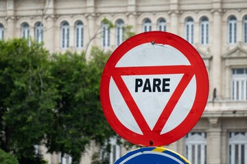 Round traffic sign with STOP translated to English (PARE in Spanish and Portuguese)