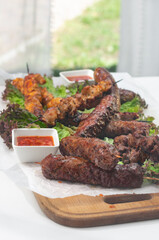made dish of skewers, meat fillet. grilled chicken, beef, pork meat with bbq sauce served