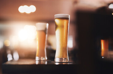 Glasses, foam and cold beer in pub for drinks as draft from pint with craft, fresh or smooth taste....