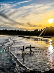 Naklejka premium Girls Surfing at Sunset in Tofino