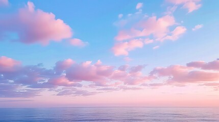 Obraz premium Cirrus clouds tinted pink by the sun at sunset over a calm blue ocean