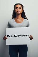 Girl, portrait and protest for rights in studio with board, sign and poster for self decision or...