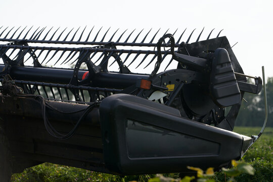 Close-up fragment of a cutterbar with a conveyor belt for windrowing in the field. Preparing fodder for livestock.