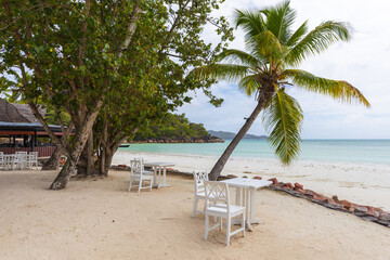 Cote D'Or Beach, Praslin island. Seychelles seaside view with white wooden tables