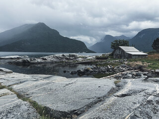 Gloomy Norway hut in front of fjords in July