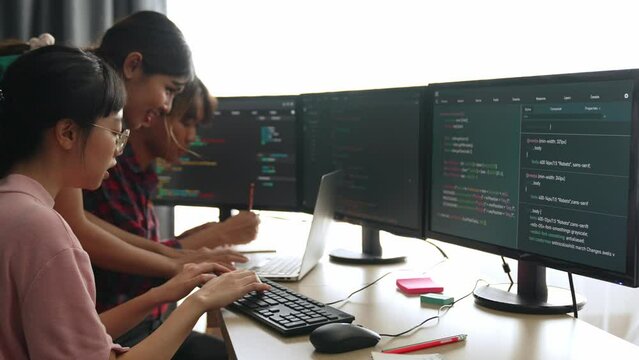 Slow motion back end software developer engineer for computer programming working together on debugging writing computing code, solving complex algorithms display on monitor in office. Burgeoning