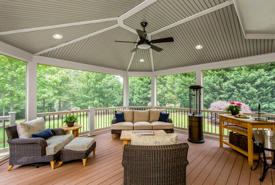 Covered Gazebo With Comfortable Seating And Ceiling Fan Amidst Green Lawn