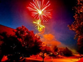 Large, red and green fireworks lighting up a neighborhood street