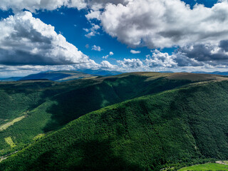 Aerial View of Rolling Green Mountains and White Clouds in the Sky