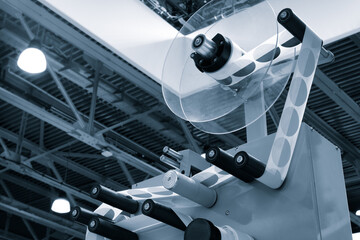 A roll of white paper is passed through the machine. printer and sticker machine, which is used for...