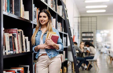Girl, college student and books in library for portrait, smile or learning for development at academy. Woman, study and happy by shelf for research, scholarship or education at campus in Australia