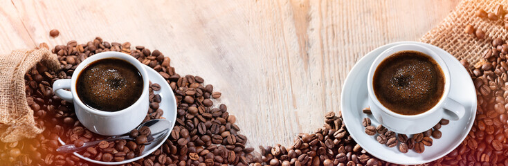 Coffee beans with a cup of coffees on a wooden table