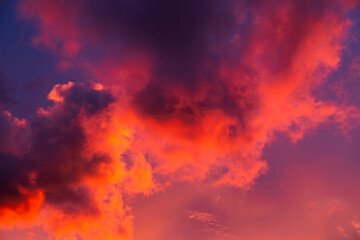 Amazing sunset with beautiful cumulus clouds coloured  pink, red, orange, purple by the sun. Dramatic celestial landscape.