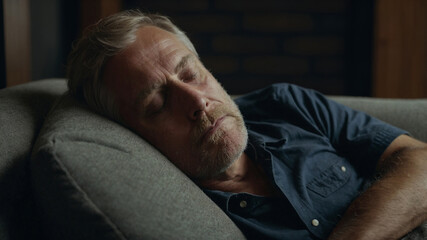 man sleeping on couch taking a nap during the day