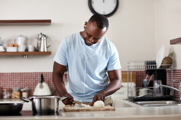 Cooking, music and vegetables with black man in kitchen of home for diet, health or nutrition recipe. Food, ingredients and onions with happy person at counter in apartment for meal preparation