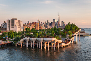 Long exposure of Little Island over the Hudson River in Chelsea, New York, with the lower Manhattan skyline as a stunning backdrop at dusk.