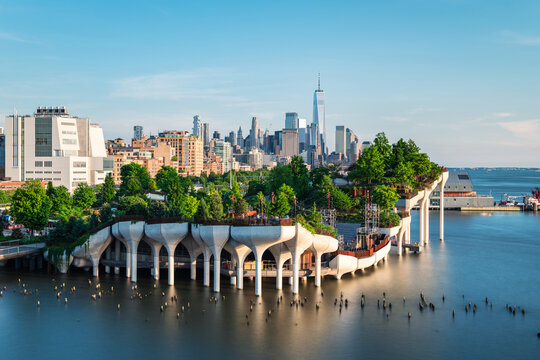 Long exposure of Little Island over the Hudson River in Chelsea, New York, with the lower Manhattan skyline as a stunning backdrop at dusk.