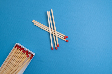 Box with new matchsticks on color background. Scattered wooden matches without a box close-up. Design