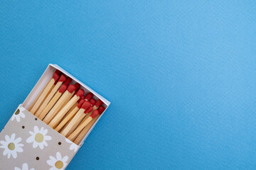 Box with new matchsticks on color background. Scattered wooden matches without a box close-up. Design