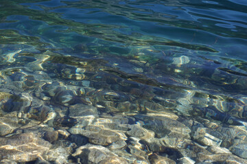 Stones under clear water in the lake. Transparent lake. 