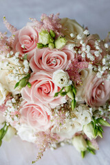 Bridal bouquet and wedding ring with a gemstone close-up. Wedding bouquet of roses in a hotel room. Preparation for the wedding ceremony. Bride's wedding accessories